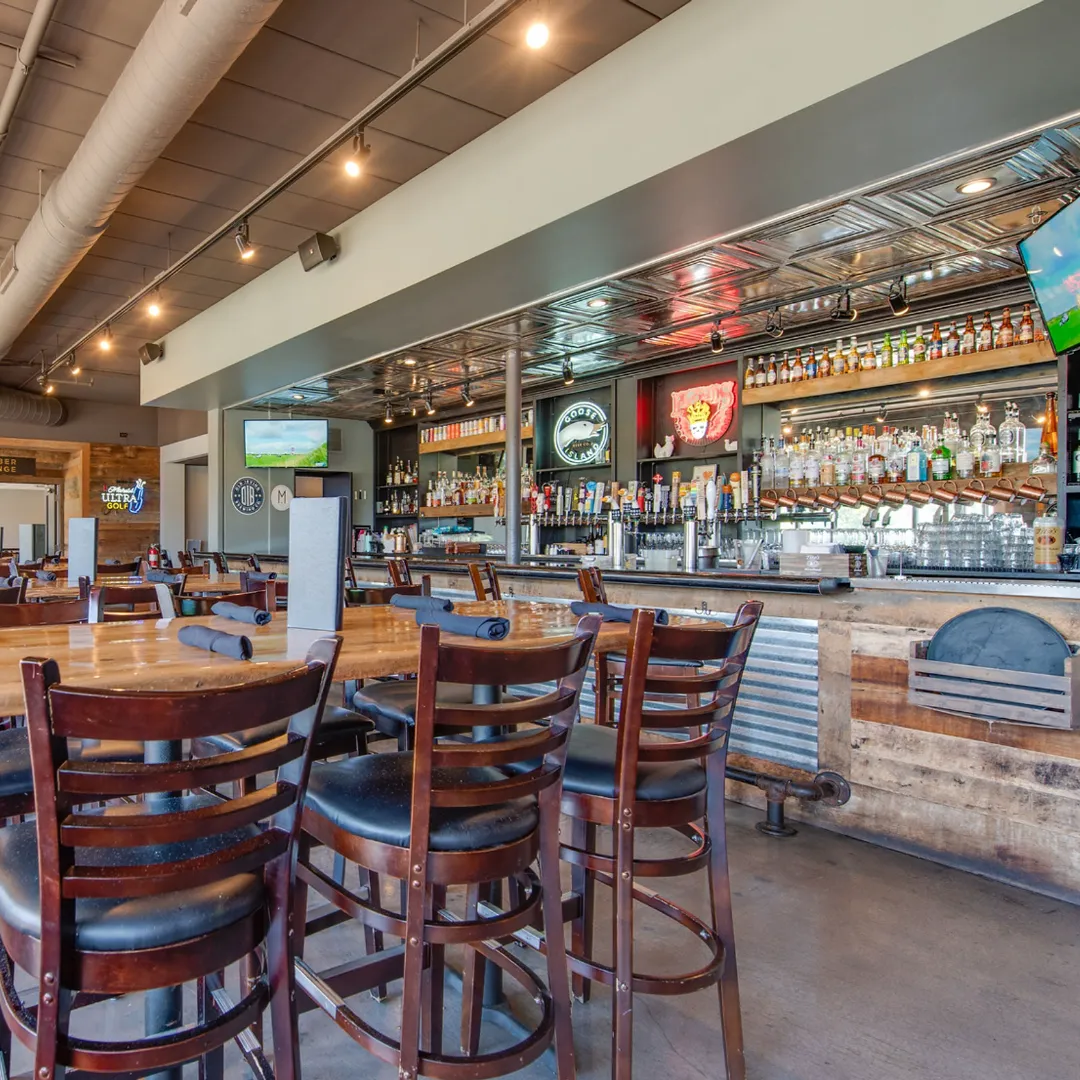 The wood-and-brick bar at the Fox & Turtle pub with high-backed stools